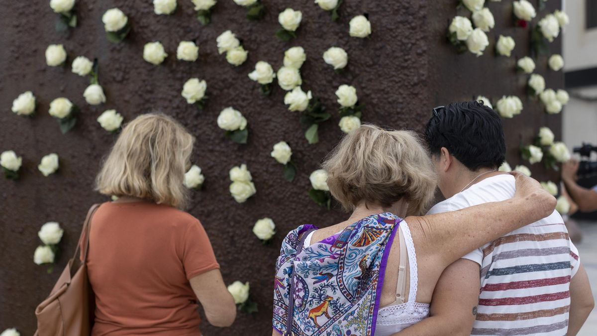 Varios familiares de los fallecidos depositan flores en el monumento Luces en el Vacío en Las Palmas de Gran Canaria.