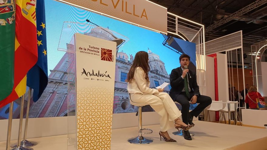 El diputado de Cultura conversa con la periodista Alejandra Cosgaya en la presentación de la oferta cultural en Fitur.