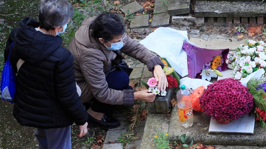 Dos personas visitan la tumba de un familiar en el cementerio de la Almudena. Miles de madrileños visitan este lunes los cementerios en los que reposan sus difuntos, después de que el año pasado la pandemia del coronavirus impidiera que cumplieran con esa tradición.
