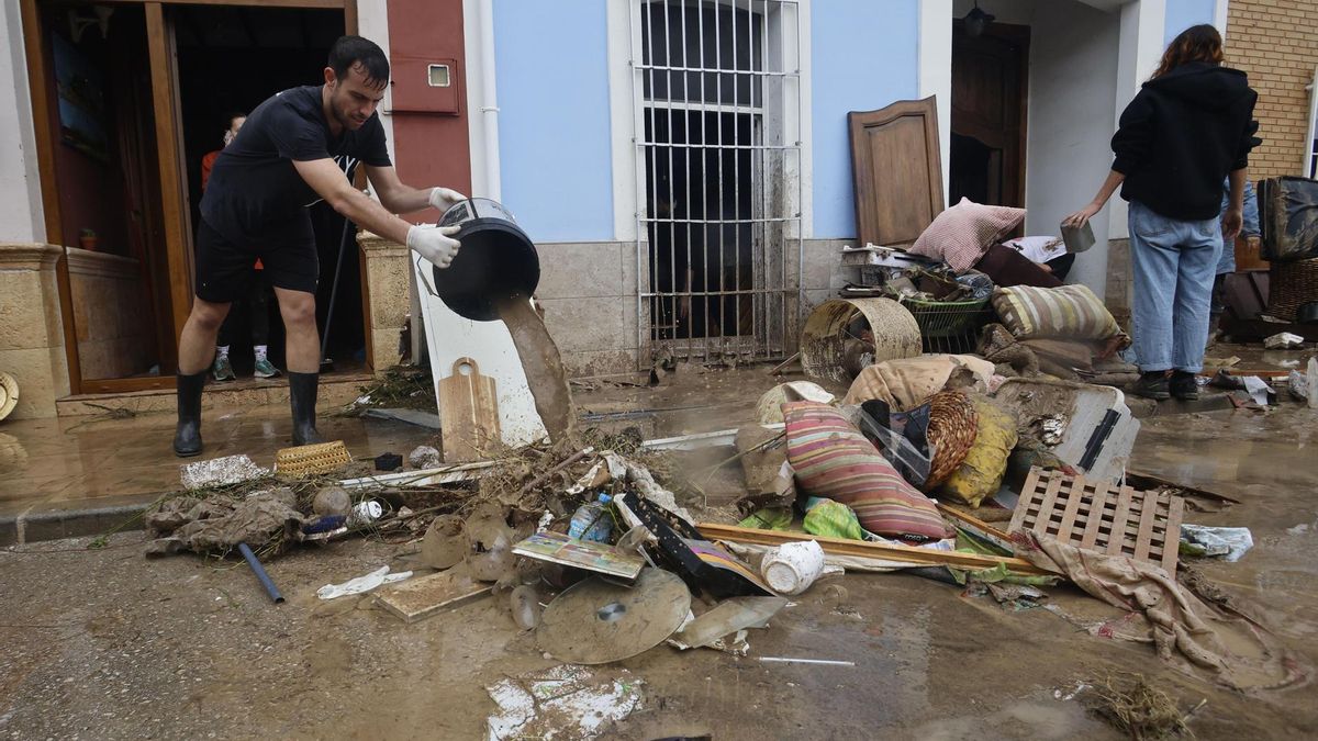 Vecinos de Els Poblets achican agua y sacan muebles afectados por la riada en Els Poblets, este lunes.