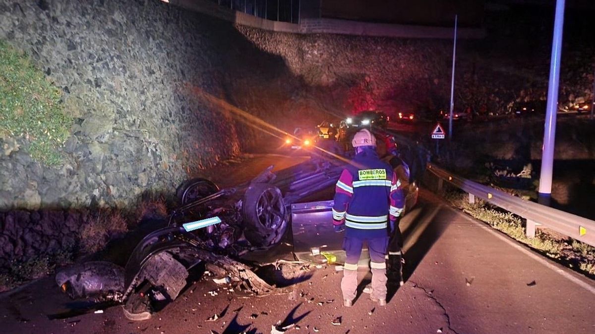 Dos bomberos junto al vehículo siniestrado.