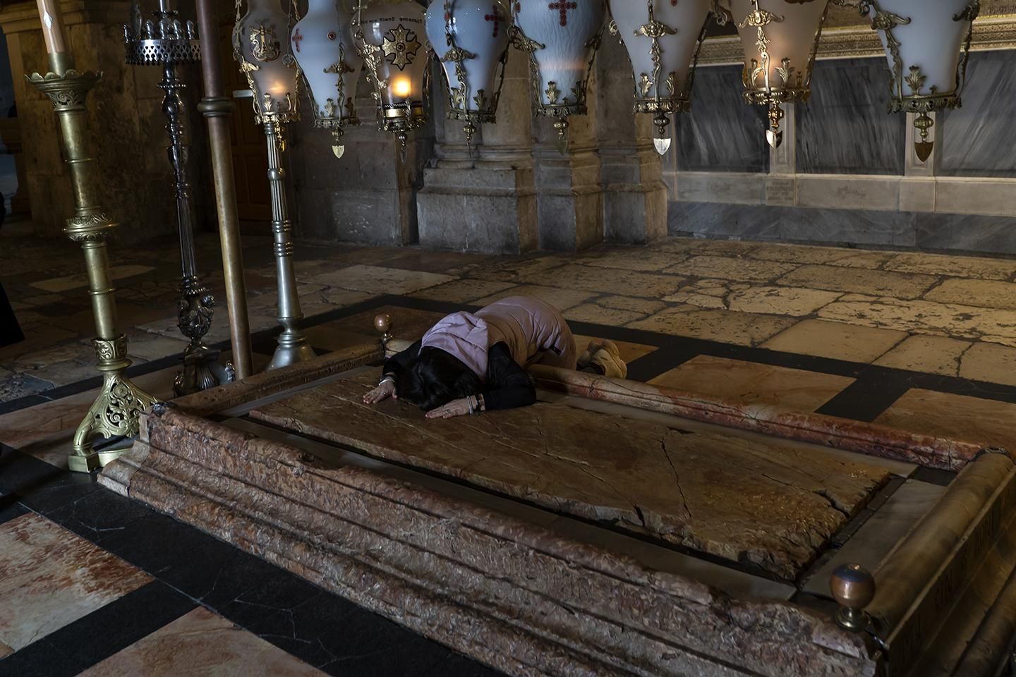 Una peregrina toca la Piedra de la Unción, donde el cuerpo de Jesús fue ungido tras ser bajado de la cruz. | JOAQUÍN GÓMEZ SASTRE