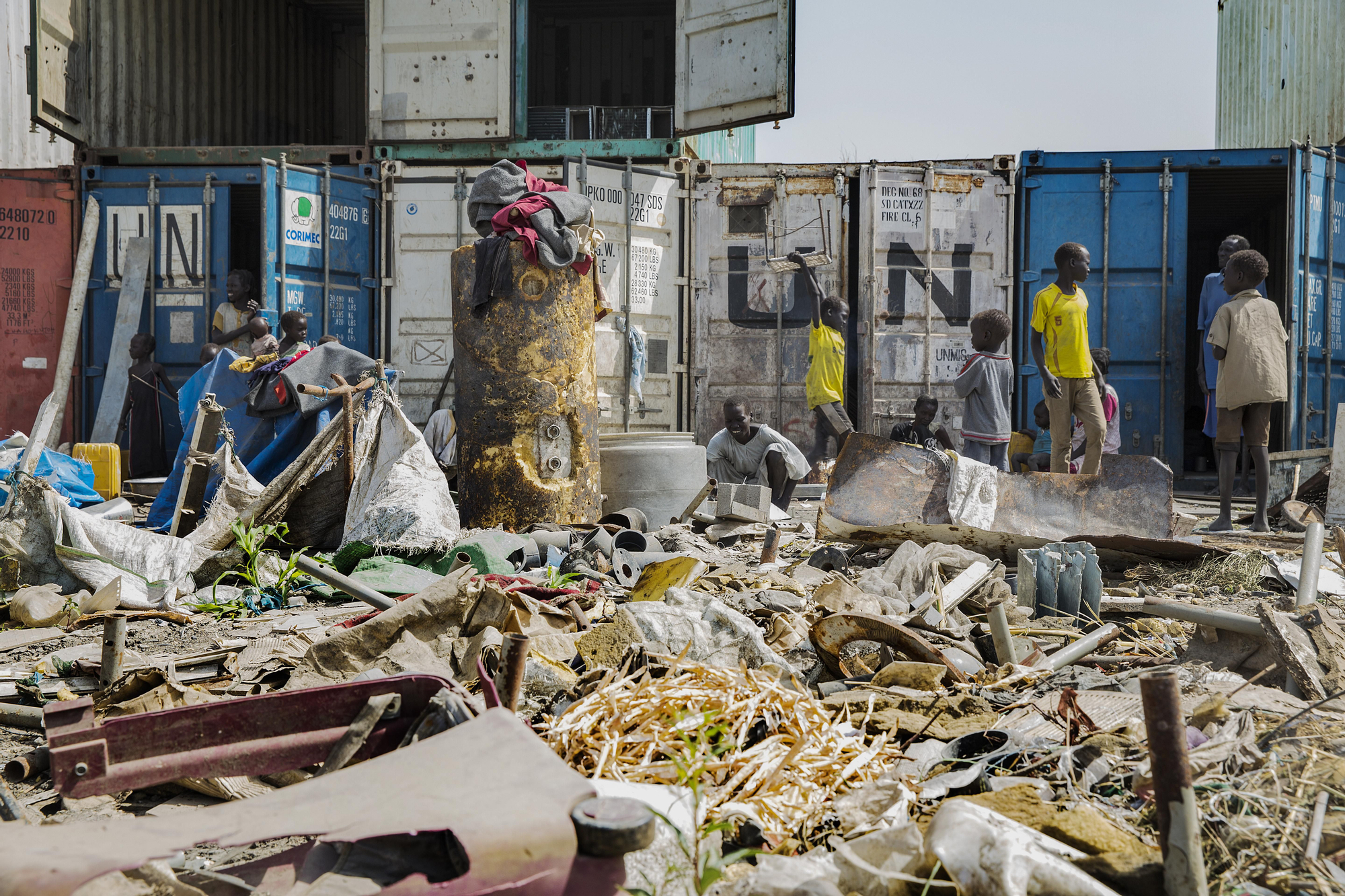 Parte de la población desplazada tiene que emplear contenedores como vivienda. Las zanjas y los callejones estrechos que separan las tiendas comunitarias (que acogen a grupos de más de 50 personas) están repletas de lodo y agua estancada. Fotografía: Anna Surinyach/MSF