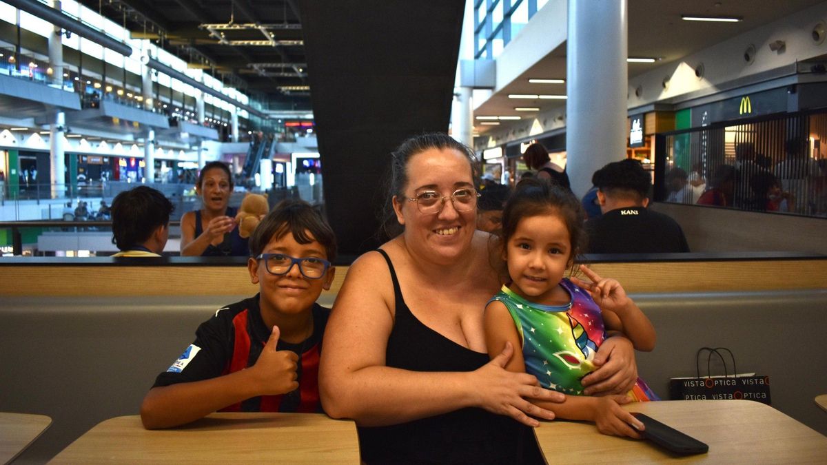 Luz María Rius y sus dos hijos se resguardan del calor en el centro comercial Màgic de Badalona