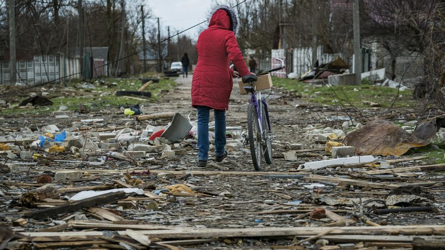 Una mujer camina con su bicicleta en medio de la destrucción en Chernígov.