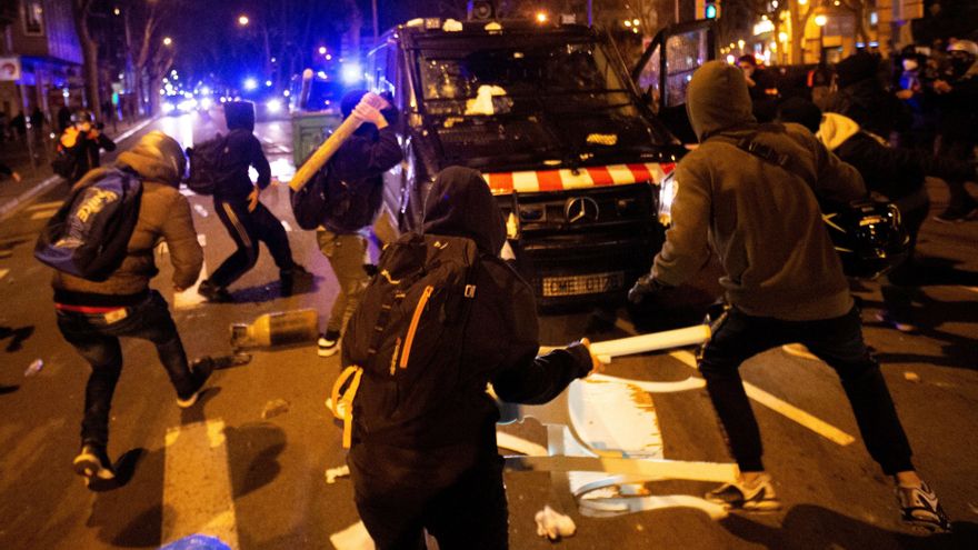 Varios manifestantes lanzan objetos a un vehículo de los cuerpos antidisturbios tras la manifestación de protesta por la detención del rapero Pablo Hasel. EFE/Enric Fontcuberta