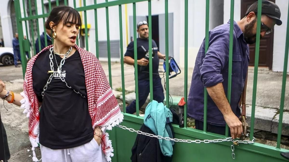Un operario de la fábrica de armas de Trubia, en Oviedo, corta las cadenas a una activista siguiendo instrucciones de la Guardia Civil