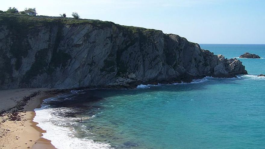 La playa de Cantabria donde podrás caminar sobre el agua hasta un islote y disfrutar de una cascada sobre la arena