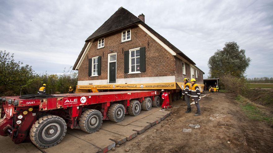 Operarios cargan la granja centenaria de Margot Ribberink para moverla un kilómetro tierra adentro.