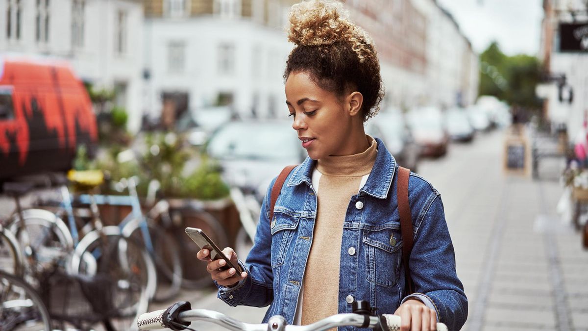 Una dona usant l'app de bicicletes compartides