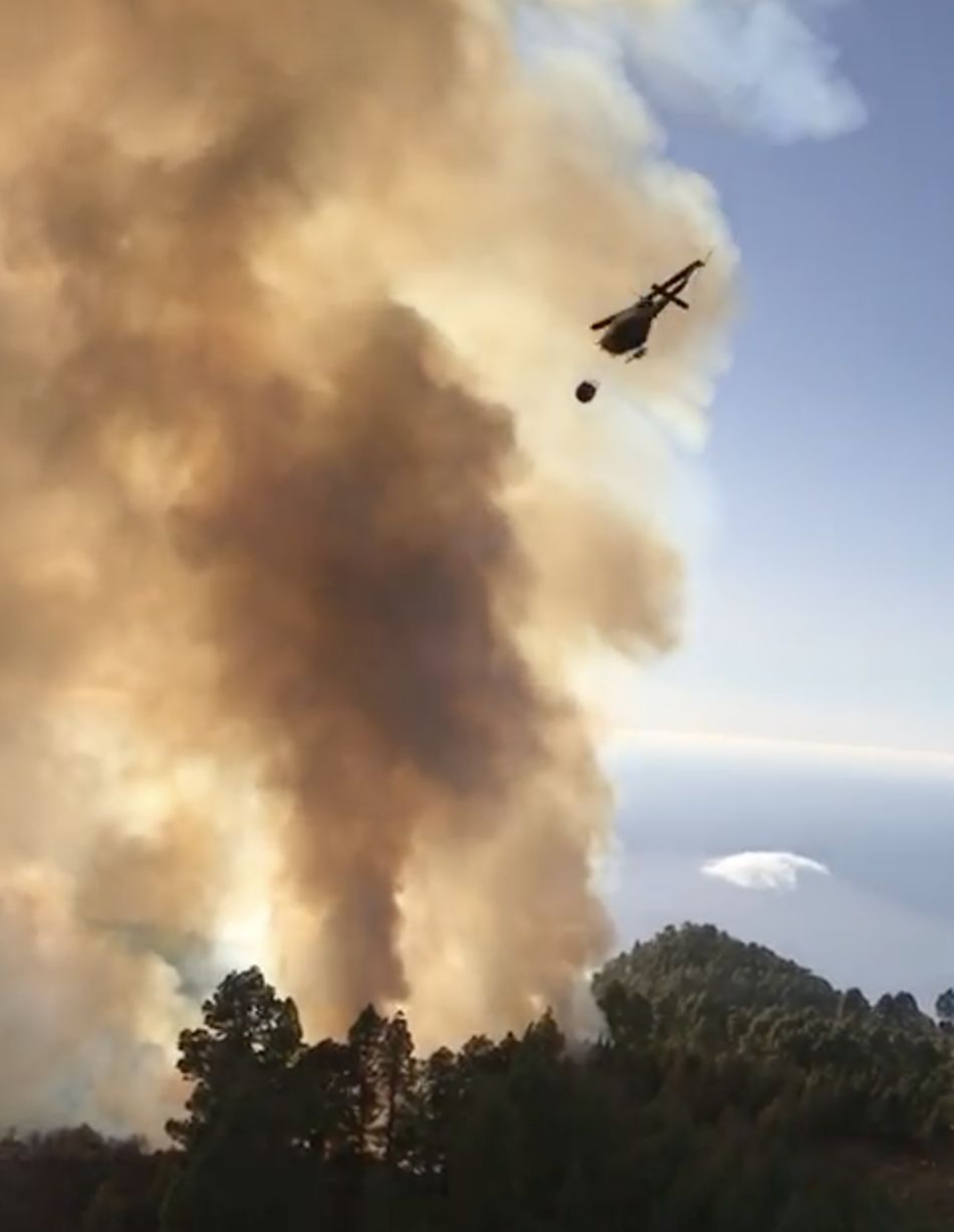 En la imagen, el  helicóptero de la BRIF realizando una descarga de agua sobre el incendio forestal en la zona de Catela, en Garafía.