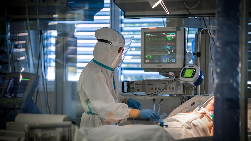 Un sanitario cuida a una persona con COVID-19 que está en la UCI.