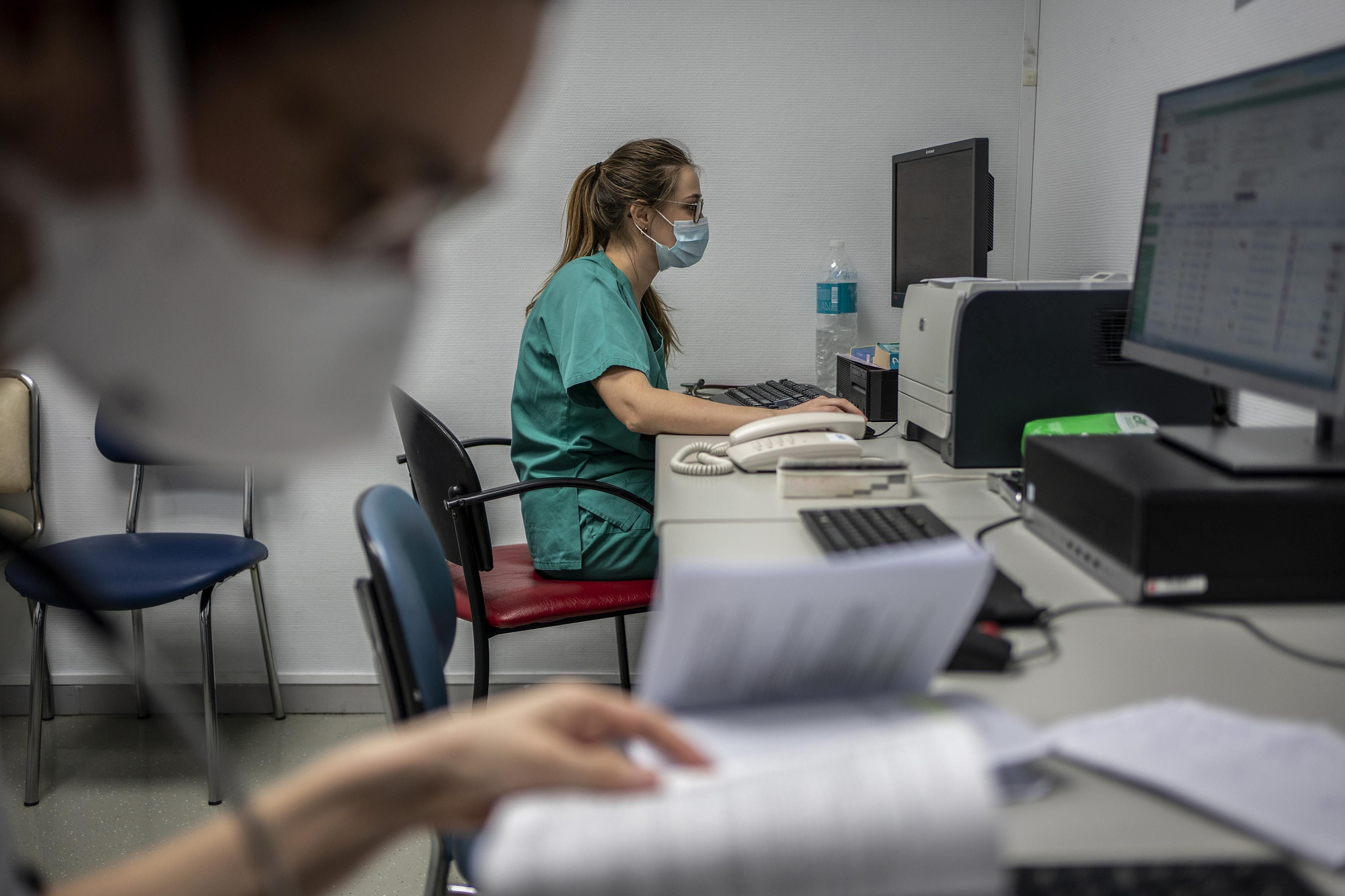 Dos médicos residentes trabajando en una sala del área de urgencias.
