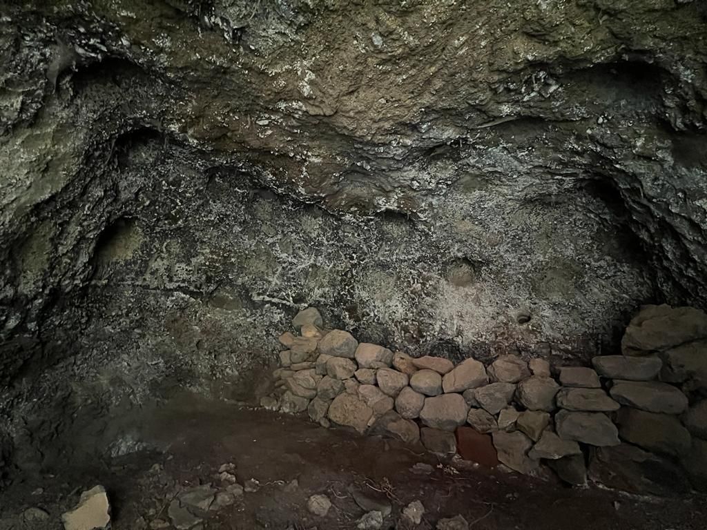 Interior de la cueva artificial con camastro de piedras y cúpulas en Tijarafe.