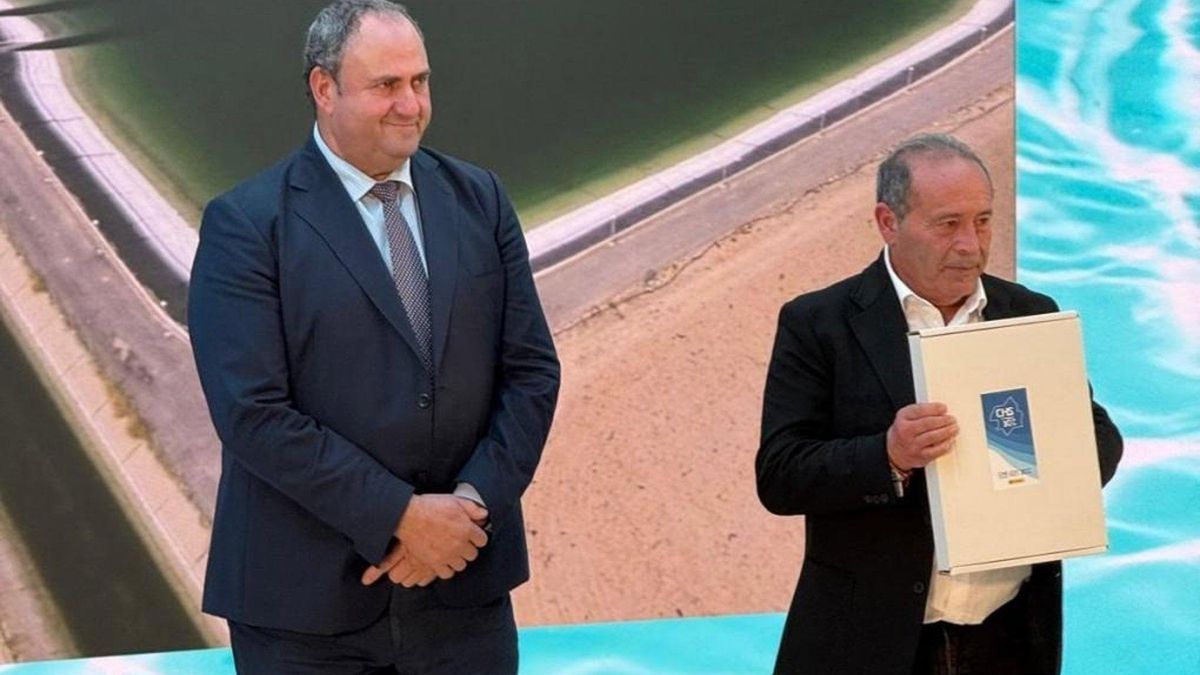 El consejero entrega el reconocimiento a los regantes.