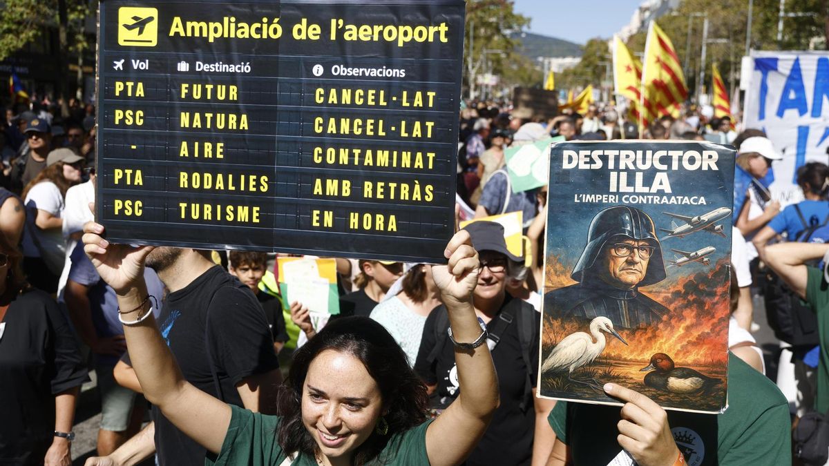 Varias personas muestran pancartas durante la manifestación contra la ampliación del aeropuerto de El Prat.