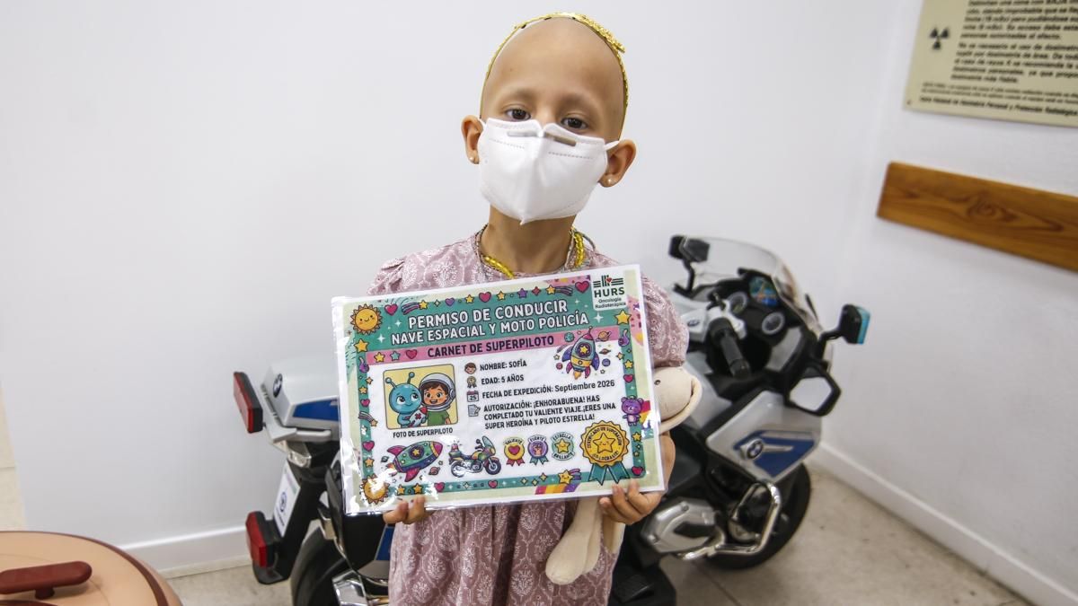 Sofía con su carné para conducir naves espaciales y motos de policía en Oncología Radioterápica.