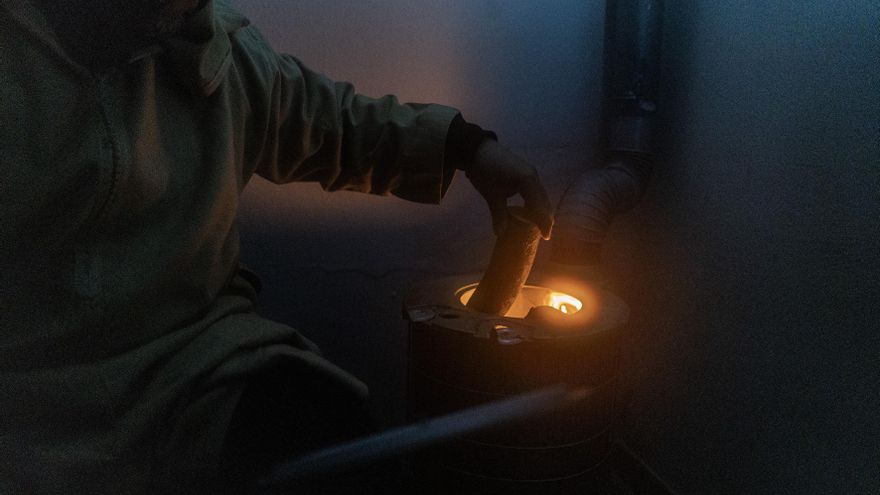 Un hombre se calienta en su casa en la Cañada Real.