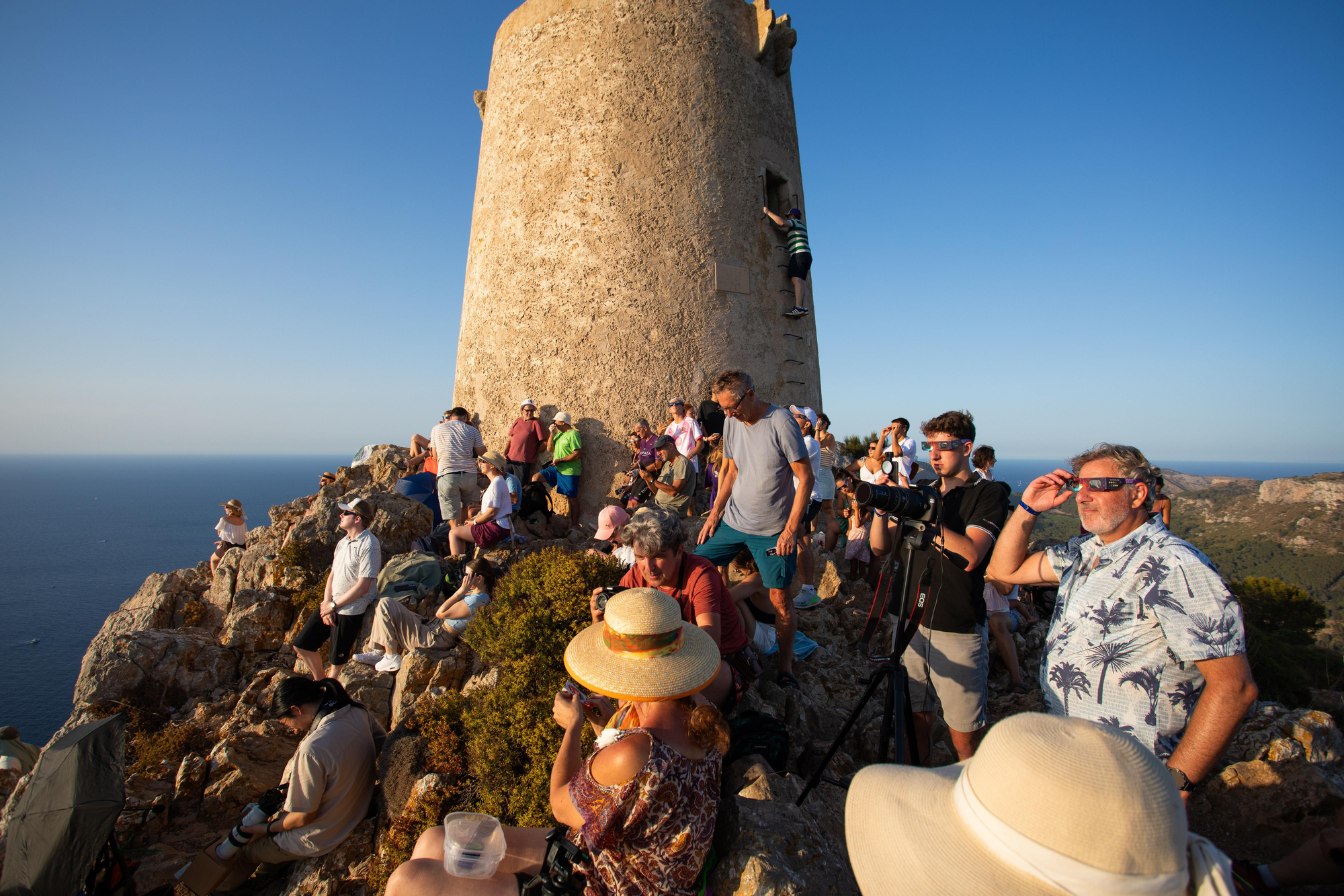 Varias personas durante el eclipse solar total desde la costa de Mallorca