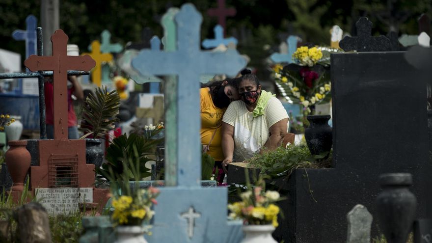Dos mujeres visitan hoy la tumba de un familiar, durante la celebración del Día de los Muertos en Managua (Nicaragua). EFE/Jorge Torres