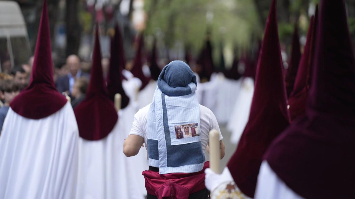 Un costalero entre los nazarenos del palio de la hermandad del Cerro.