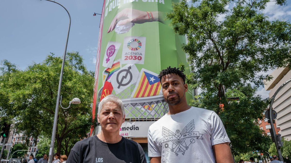 La presidenta de la Federación Estatal LGTBI+, Uge Sangil y el presidente de COGAM, Ronny de la Cruz, posan frente a la lona que Vox ha instalado en la calle Alcalá, 145, a 19 de junio de 2023, en Madrid (España).