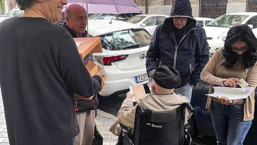 Los miembros de una mesa electoral del instituto Santa Engracia de Madrid han sacado una urna a la calle para facilitar que un anciano en silla de ruedas pudiera votar por no tener rampa