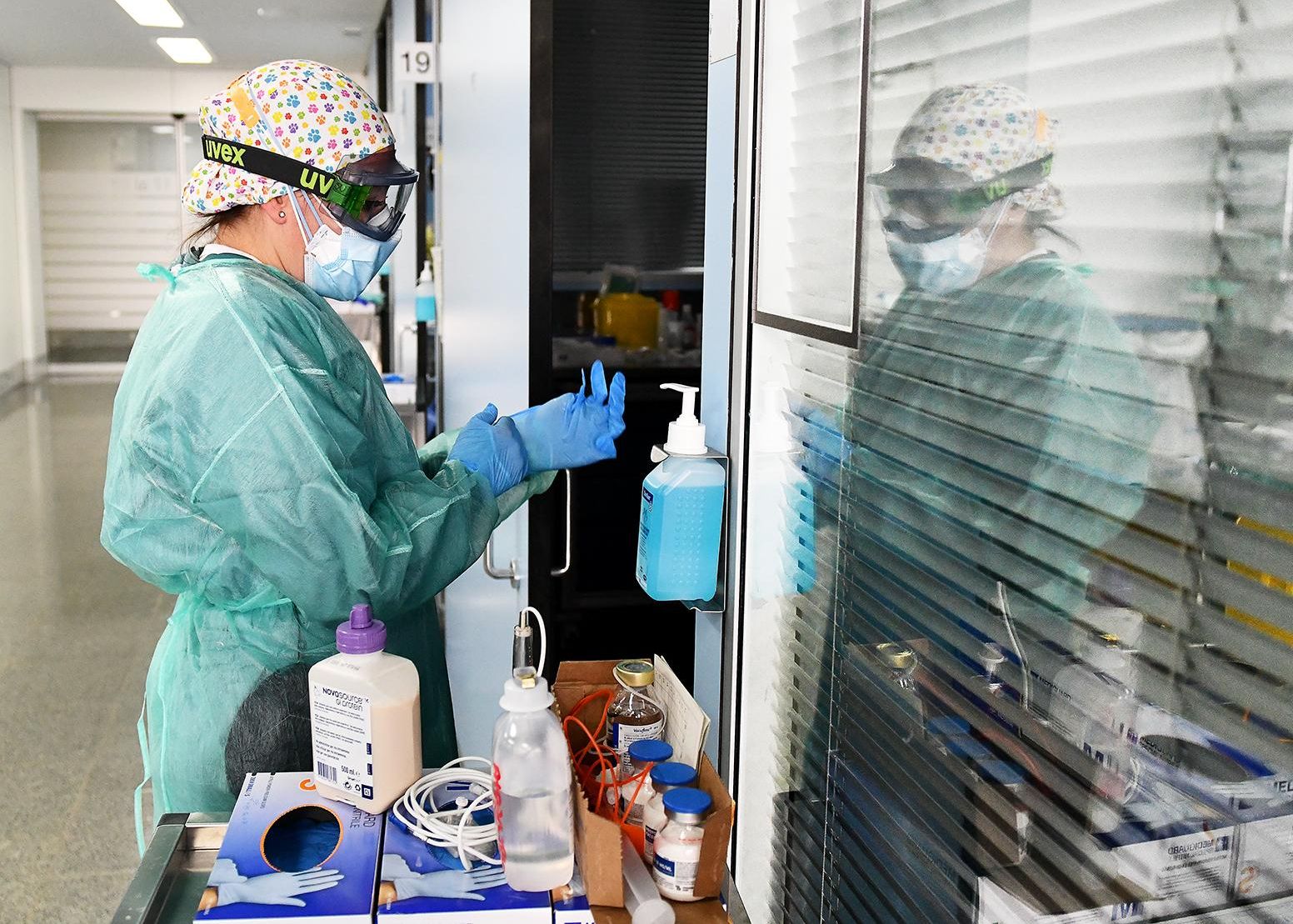 Una enfermera se pone los guantes para entrar a un box de la UCI del Sant Pau