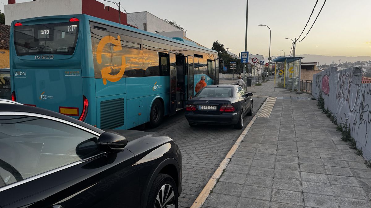 Dos coches aparcados en la parada frente a la calle La Tornera impiden que la guagua pueda dejar a los pasajeros en la acera.