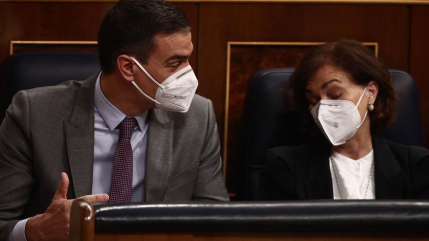 El presidente del Gobierno, Pedro Sánchez, conversa con la vicepresidenta primera, Carmen Calvo, en el Congreso de los Diputados, Madrid, (España)