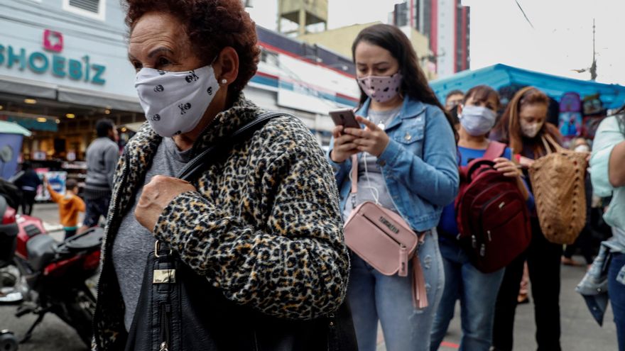 Personas con tapabocas hacen fila en un sector comercial de Sao Paulo (Brasil). EFE/Sebastiao Moreira/Archivo