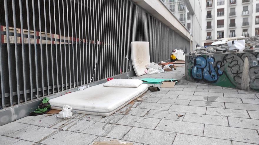 Colchones y otros enseres se amontonan pegados a la valla del patio del colegio