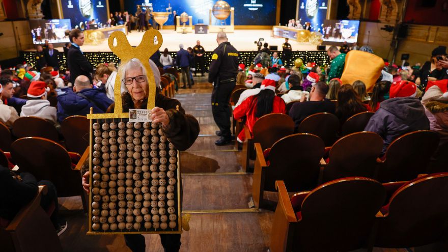 Asistentes aguardan el inicio del sorteo de la Lotería de Navidad este domingo en el Teatro Real, en Madrid.