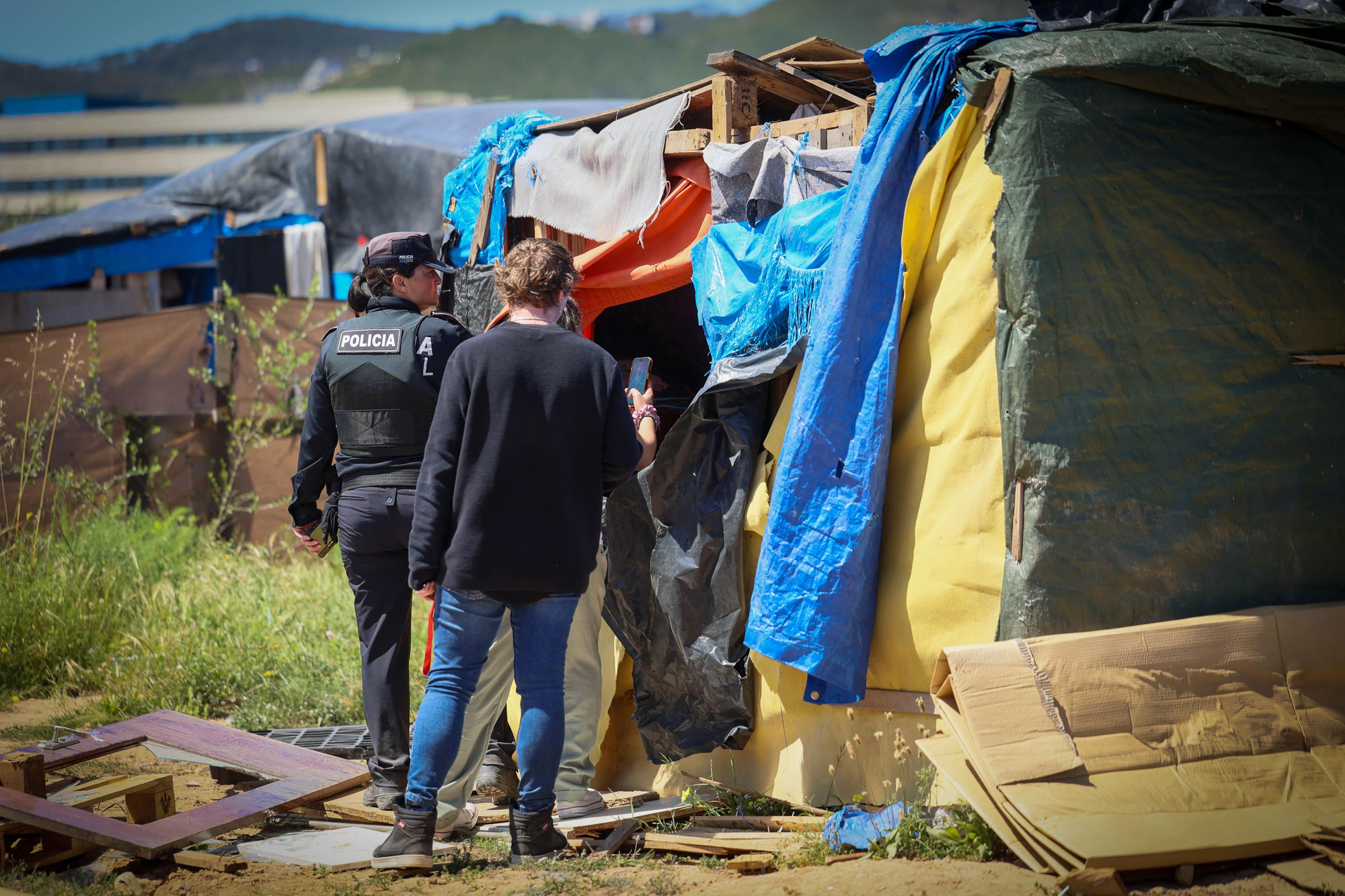 Diverses persones recullen les seves pertinences al costat d'una caravana