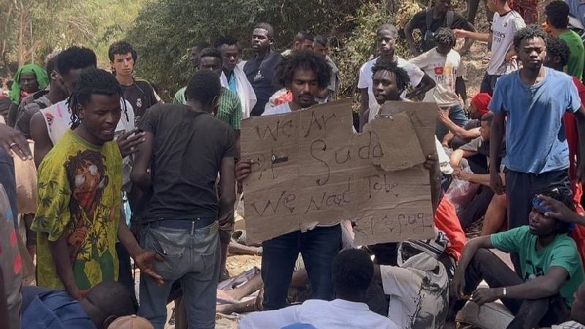 Un refugiado sudanés sostiene un cartel en el que solicita asilo a las autoridades españolas.