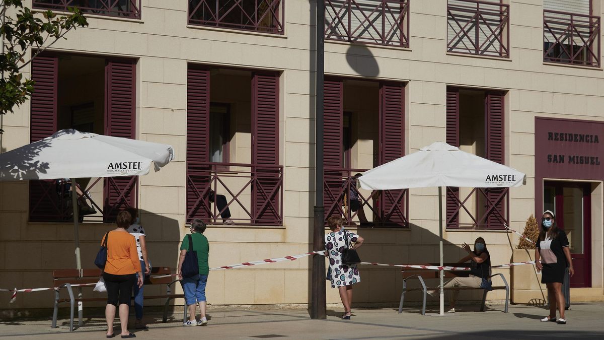 Varias vecinas de la localidad de Peralta visitan a sus familiares desde el exterior de una residencia de mayores, en Peralta