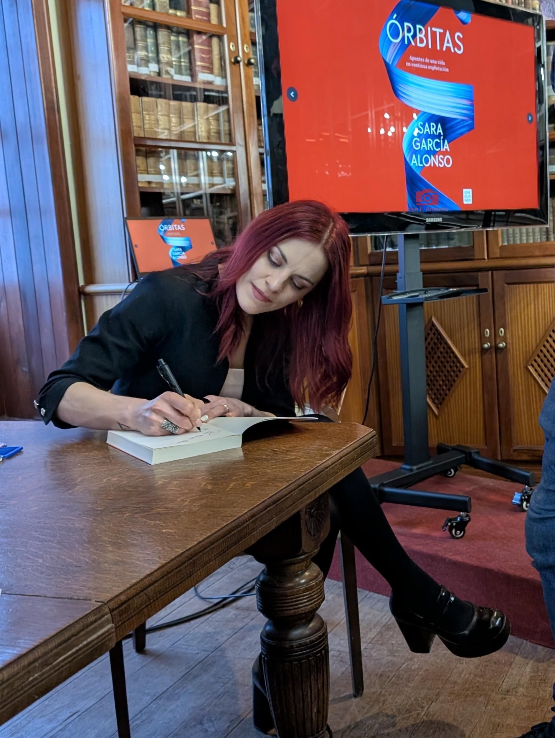 La astronauta y bióloga molecular Sara García Alonso, este  viernes en la  Real Sociedad Cosmológica, firmando su libro 'Órbitas'.