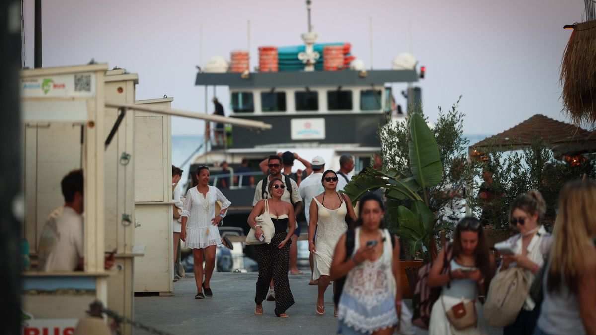 Turistas descienden del catamarán en el que han estado varias horas de fiesta.
