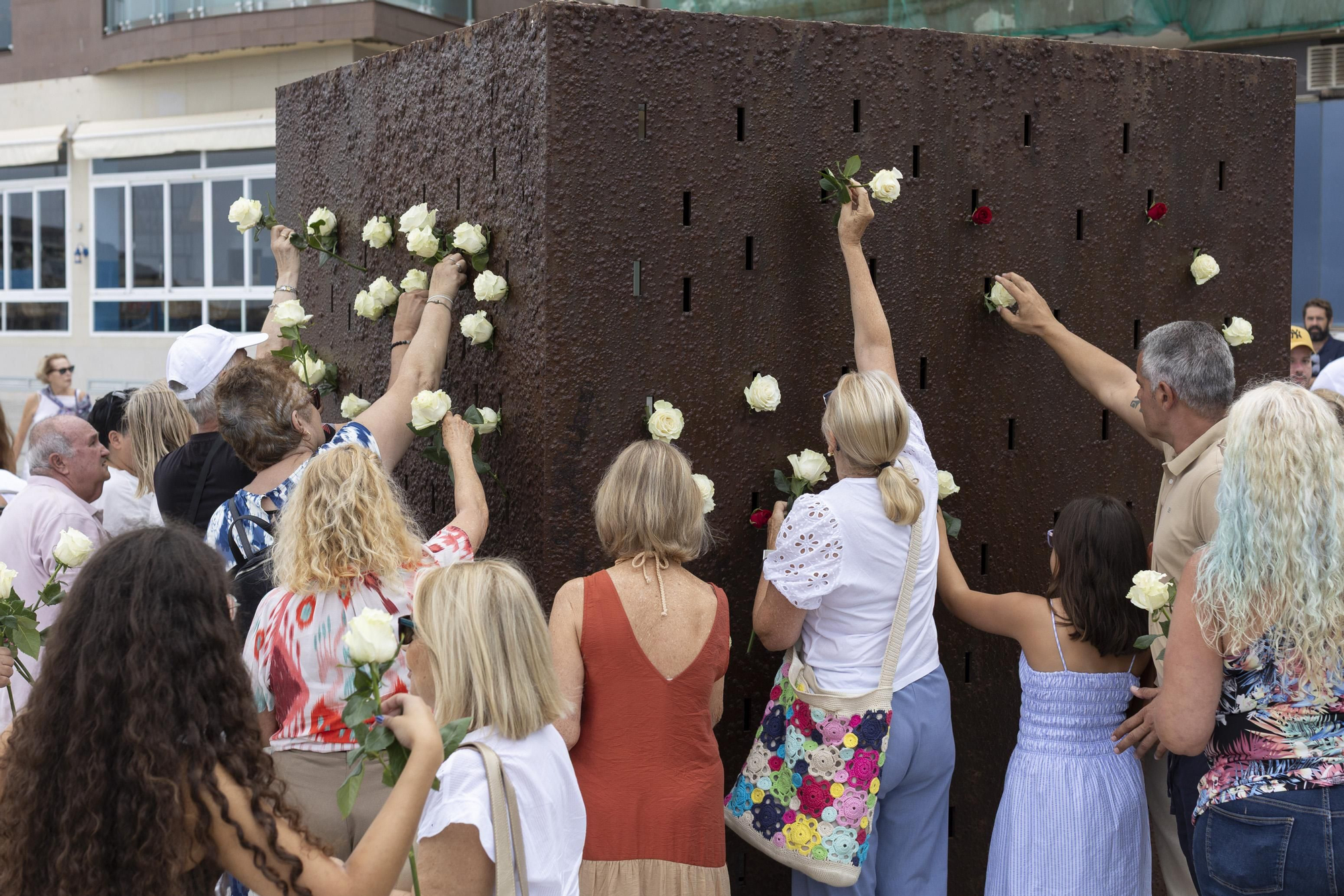 Varios familiares de los fallecidos depositan flores en el monumento Luces en el Vacío, en Las Palmas de Gran Canaria