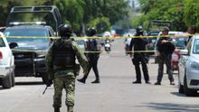Policías estatales y personal de la Guardia Nacional vigilan el lugar de los hechos donde fueron asesinados dos policías ministeriales y una mujer policía ministerial resultó herida, este lunes, en el municipio de Celaya, estado de Guanajuato (México).