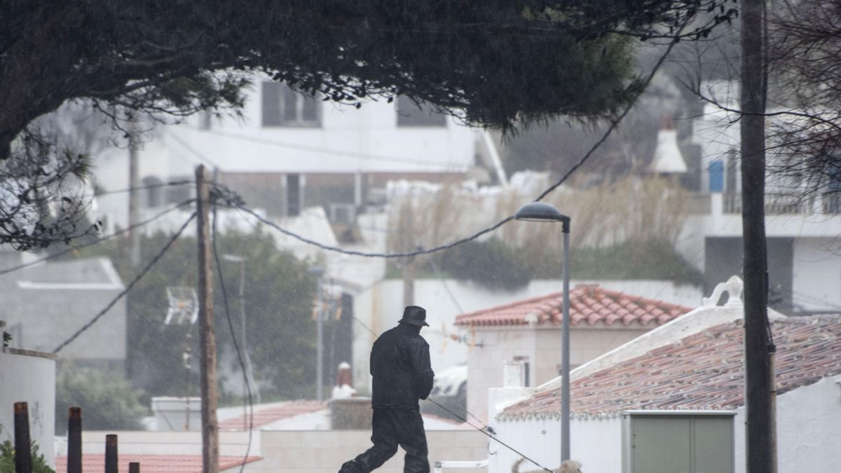Un hombre pasea con su perro por las calles de Sa Mesquida, Menorca.