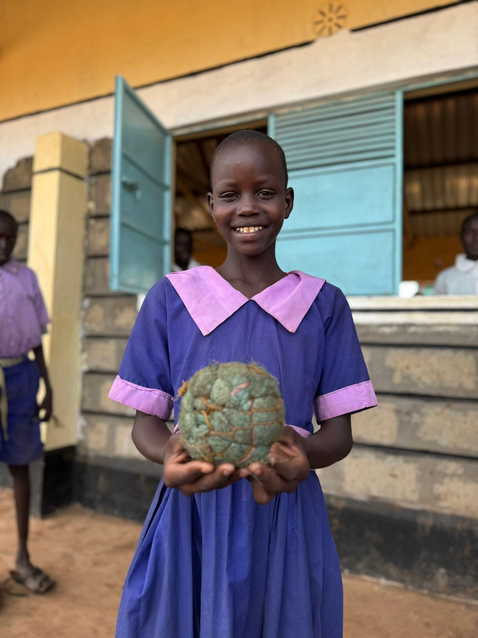 Una alumna de un Club anti-MGF con un balón fabricado con cuerda y fibras en Kenia