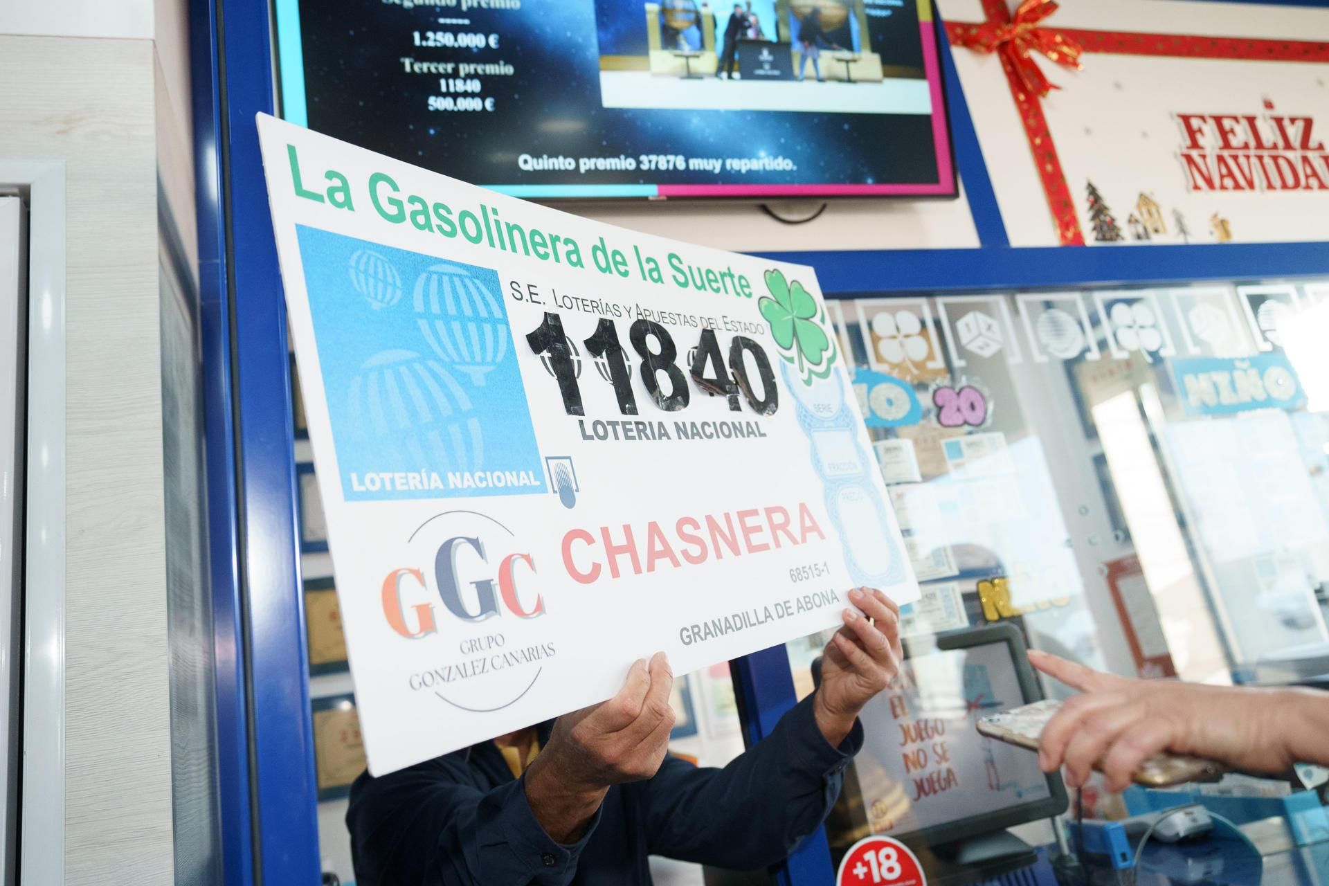 Empleados y propietarios de la gasolinera La Chasnera celebran los premios de varios de los números vendidos en su establecimiento, agraciados con un tercero, un cuarto y un quinto premio en el sorteo extraordinario de Navidad de la Lotería Nacional. EFE/Ramón de la Rocha