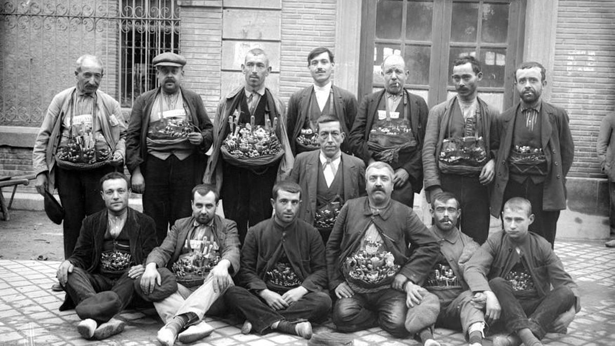 Retrato de grupo: vendedores de navajas mostrando su mercancía en la puerta de la estación de Albacete