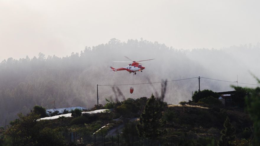 Un helicóptero carga agua desde una presa en Arico