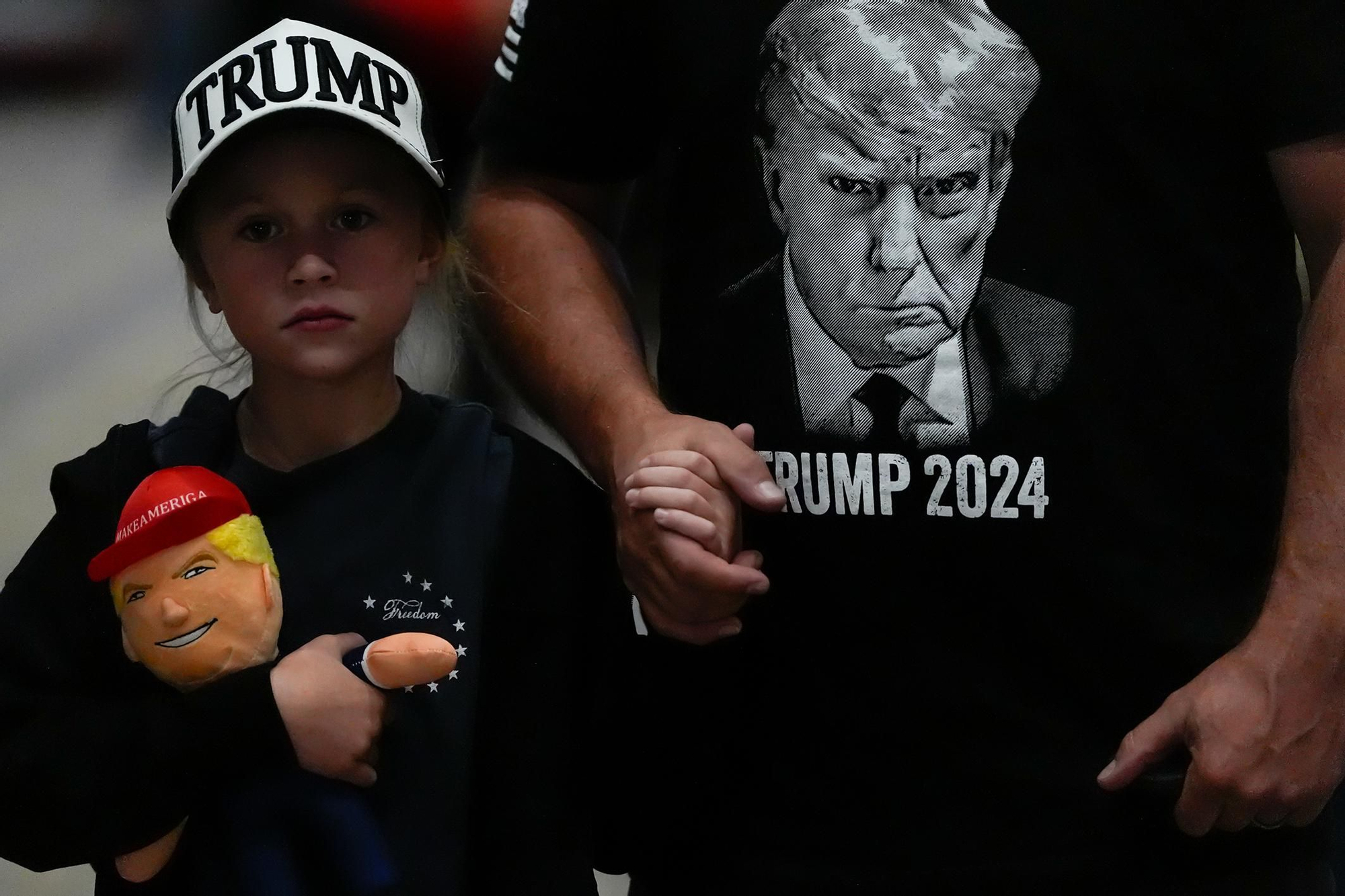 Una joven asistente sostiene un muñeco de Donald Trump antes de que el candidato presidencial hable en un mitin de campaña en el Grand Sierra Resort and Casino. Reno, Nevada, 11 de octubre de 2024.
© Julia Demaree Nikhinson / AP