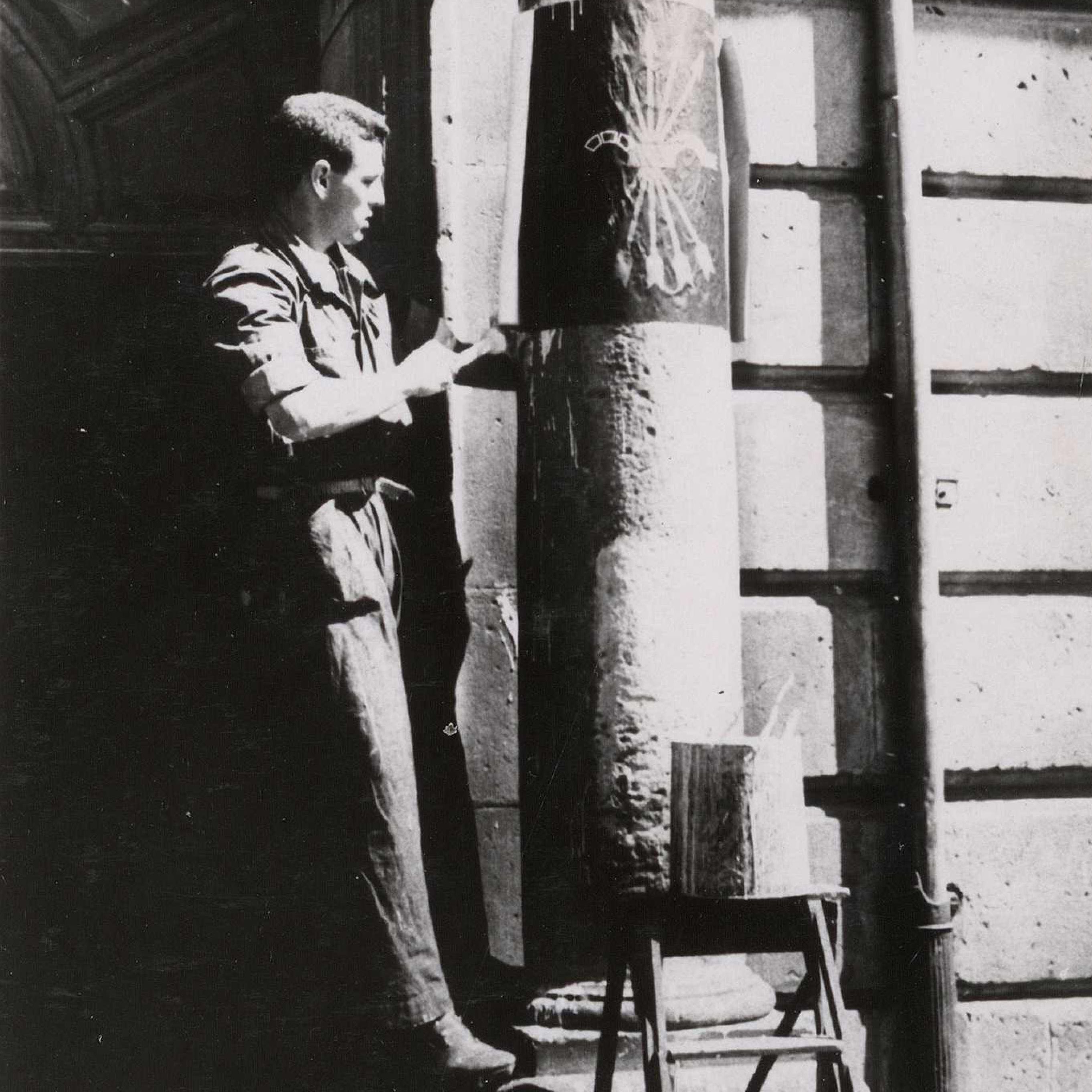 "Un phalangiste affiche le prémier symbole de F.E. dans la ville liberée".