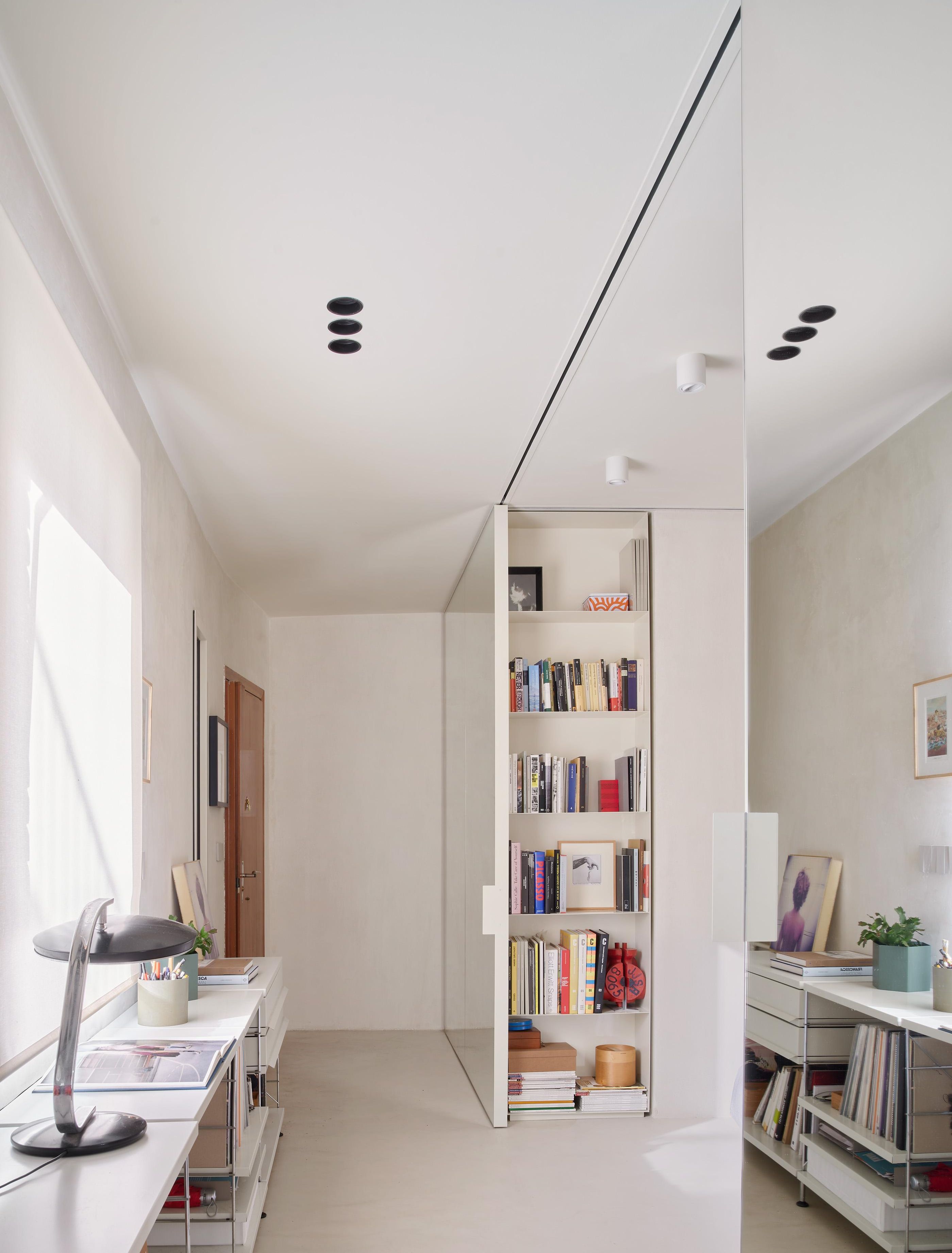 En el ático de NULA.STUDIO, la decisión de uniformar suelos, paredes y techos con mortero y yeso desnudos crea esa cámara neutra donde los objetos personales destacan sin que el espacio compita con ellos.