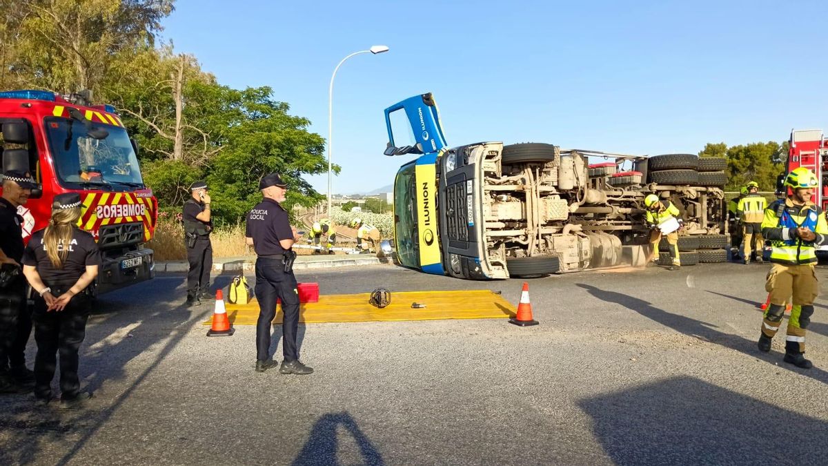Los bomberos extraen a un hombre herido tras volcar el camión que conducía
