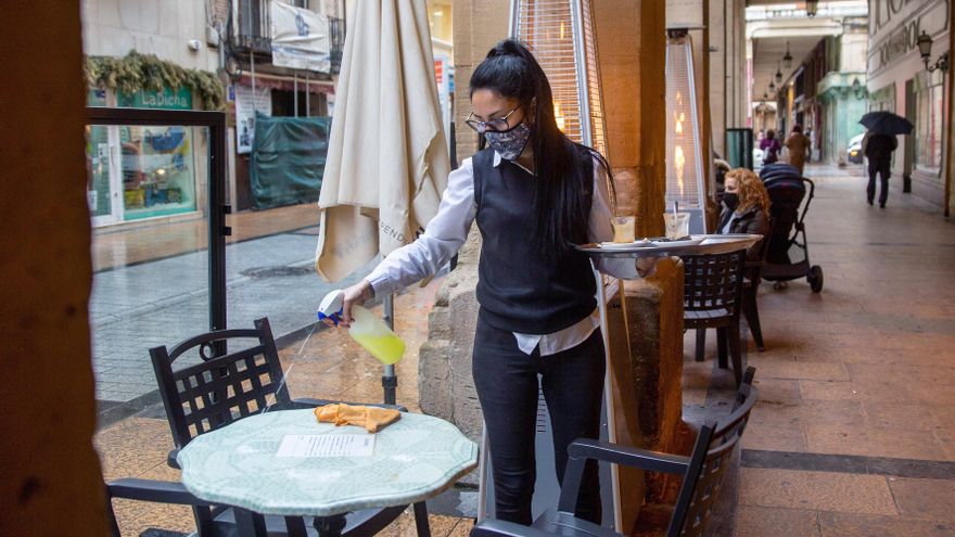 La camarera de un bar en la céntrica calle Portales de Logroño, limpia la mesa esta semana. EFE/Raquel Manzanares
